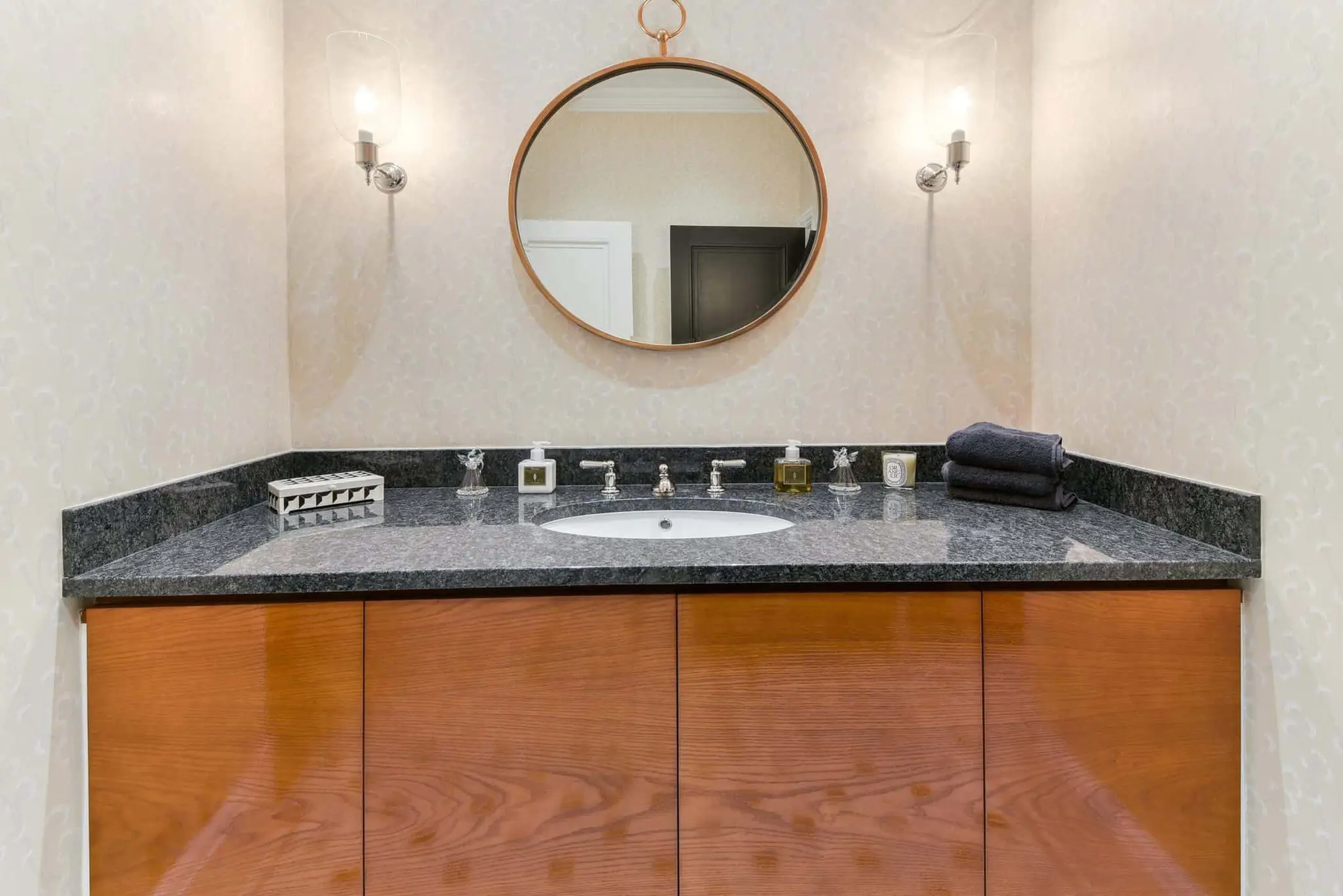 Cloakroom basin with stone worktop and round mirror