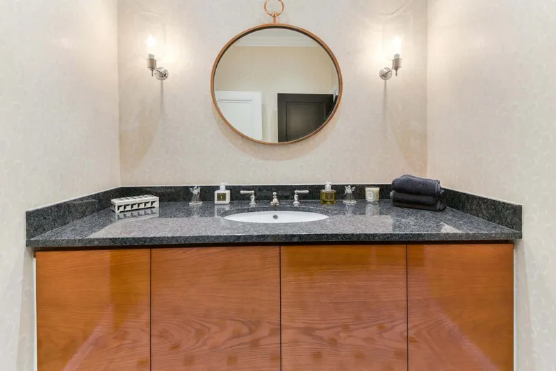 Cloakroom basin with stone worktop and round mirror