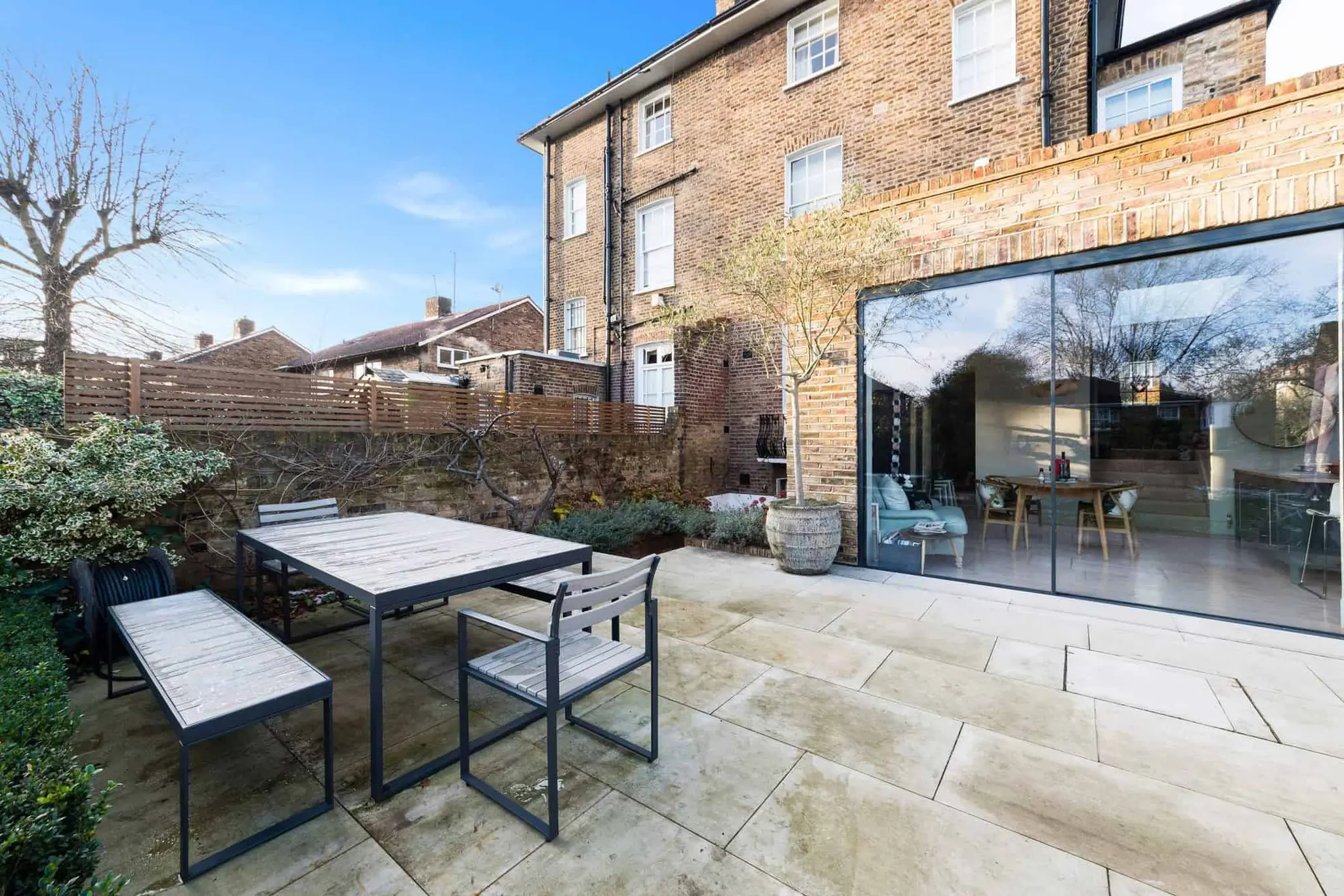 Rear terrace with full-height sliding glazing to the new kitchen extension