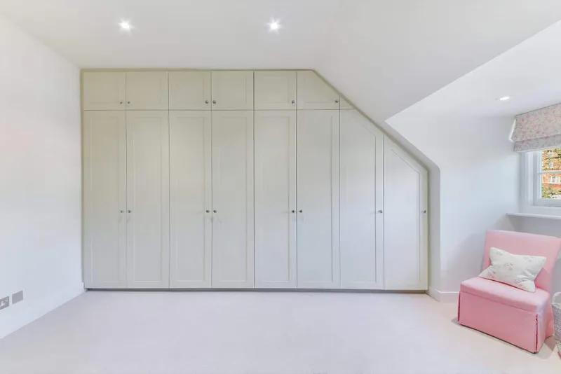 Bedroom with fitted wardrobes under a sloping ceiling