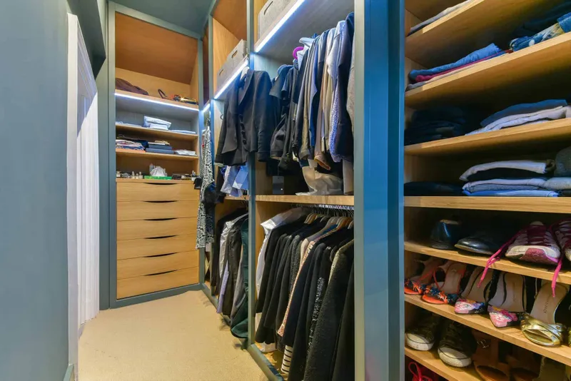 Bespoke walk-in wardrobe in oak veneer with LED strip lighting