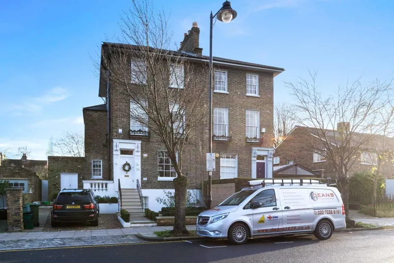 Front elevation from the street with a Deans van parked outside, showing the Portland stone steps and restored wrought-iron balustrade
