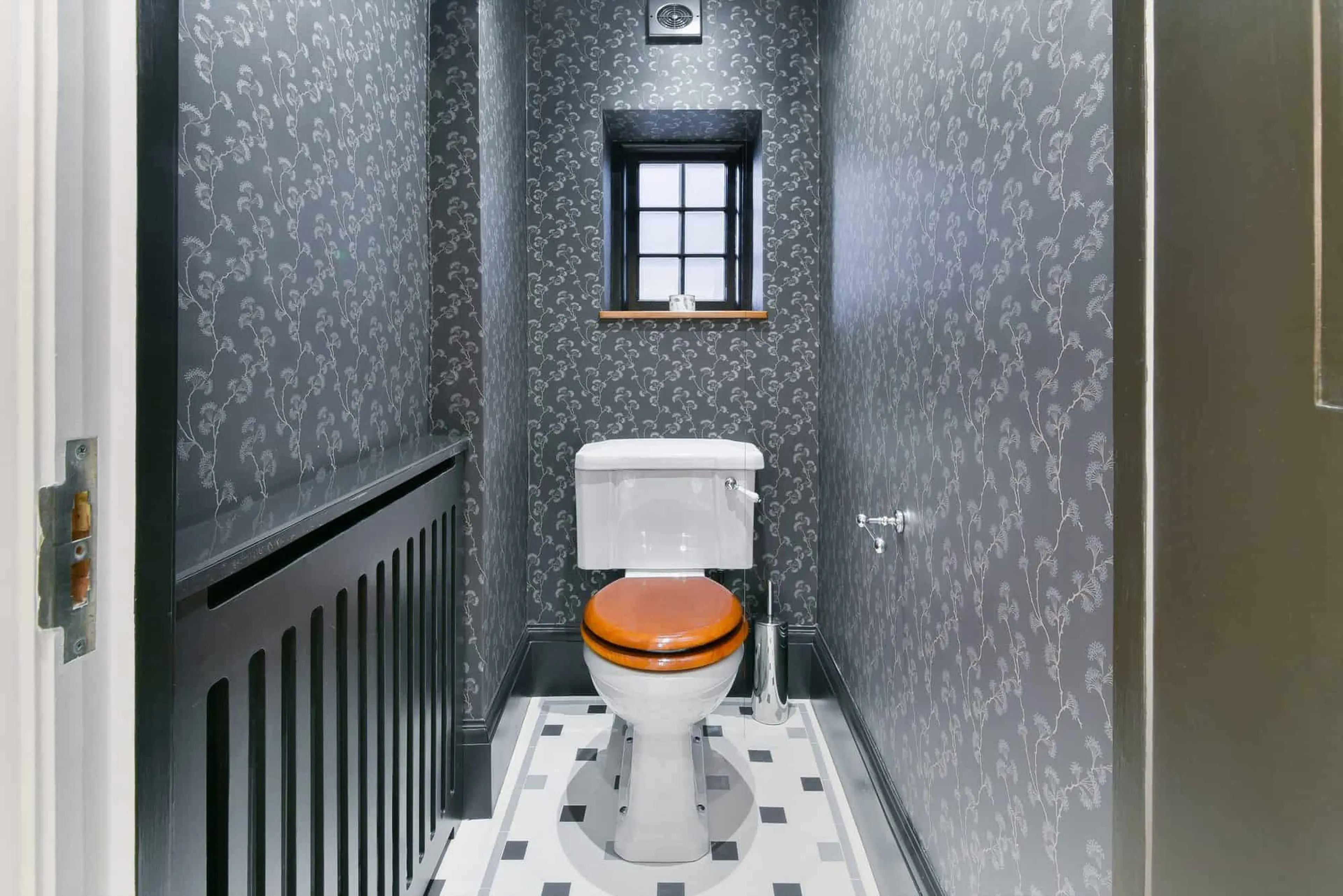 WC with hand-made patterned wallpaper and mosaic floor tiling