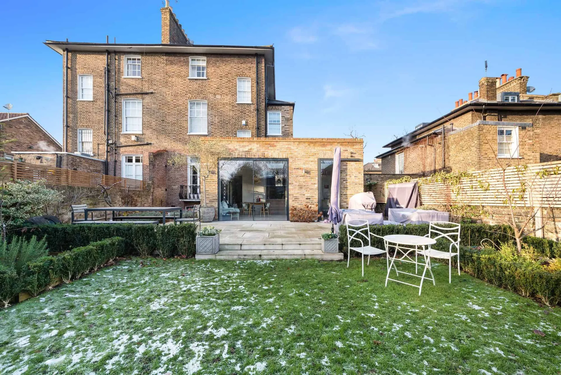 Full rear elevation seen from the garden, with snow on the lawn