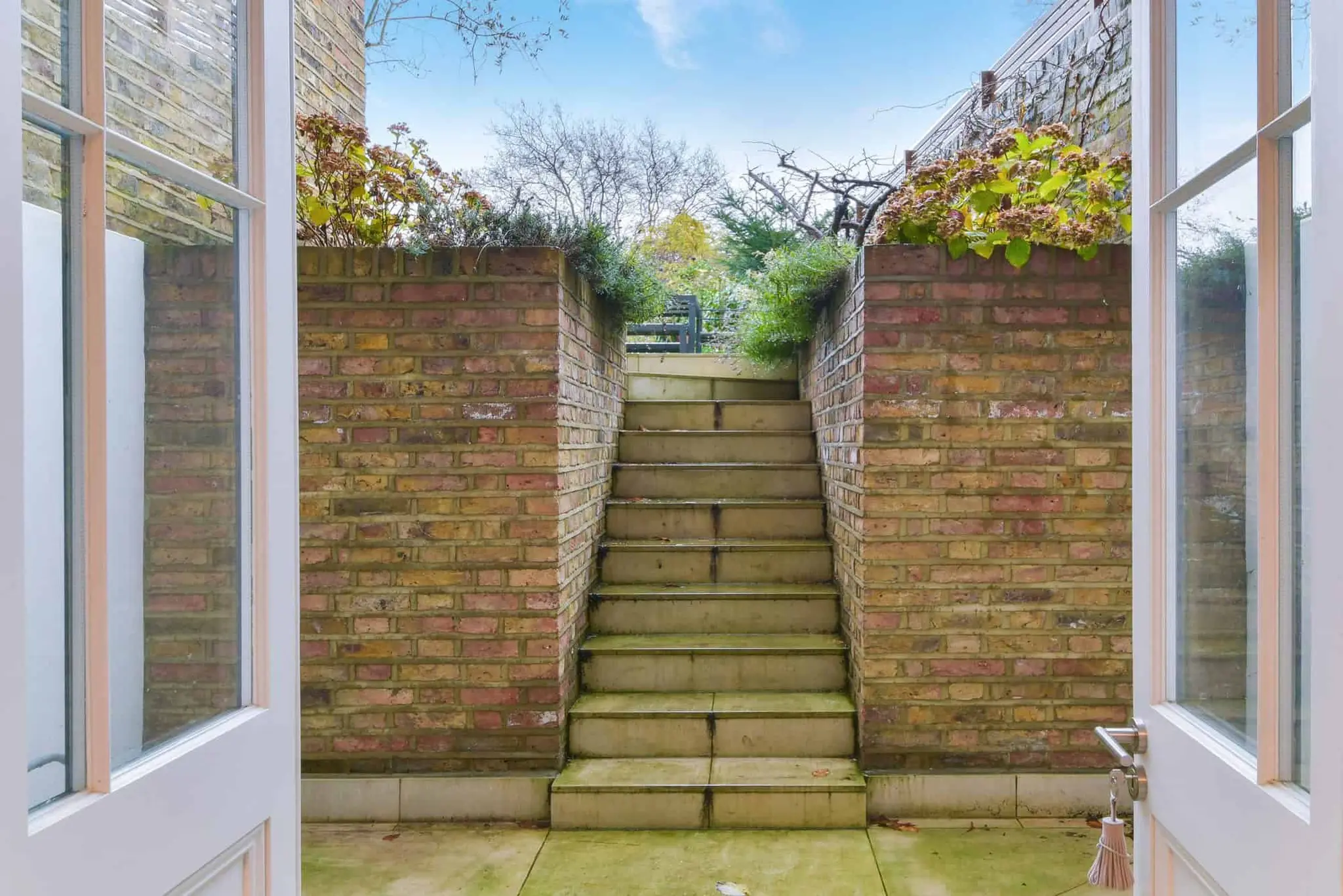 Lower-ground doors opening to the sunken courtyard steps