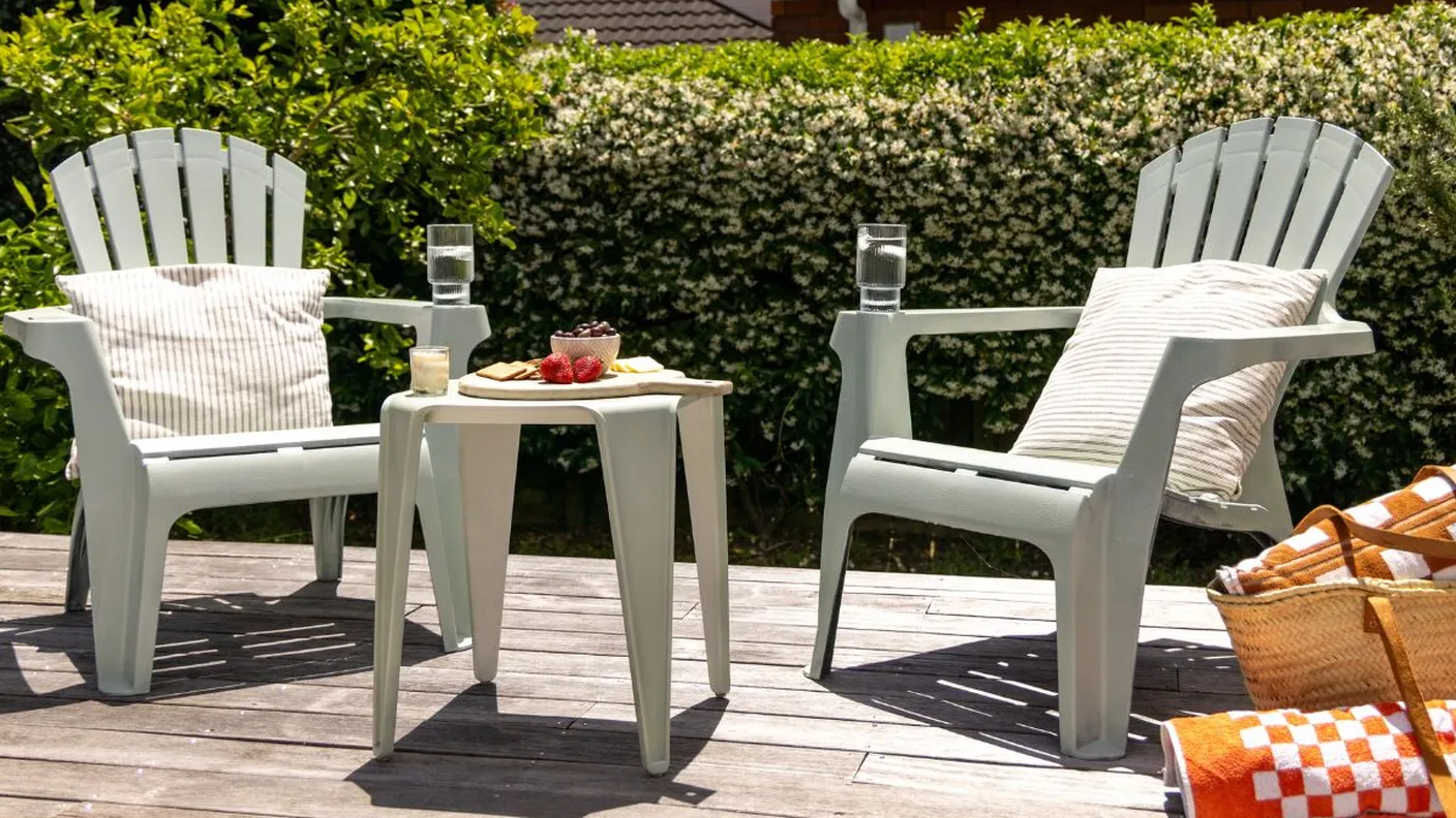 Two sage green outdoor chairs painted with White Knight Squirts, styled on a deck with cushions and snacks