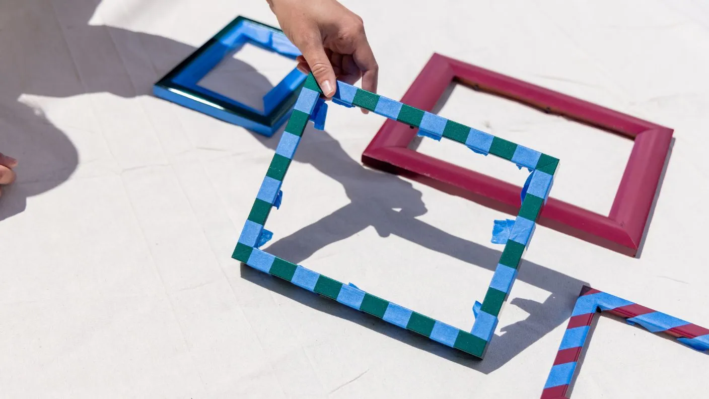 Picture frames in green, blue and red with striped pattern on drop cloth