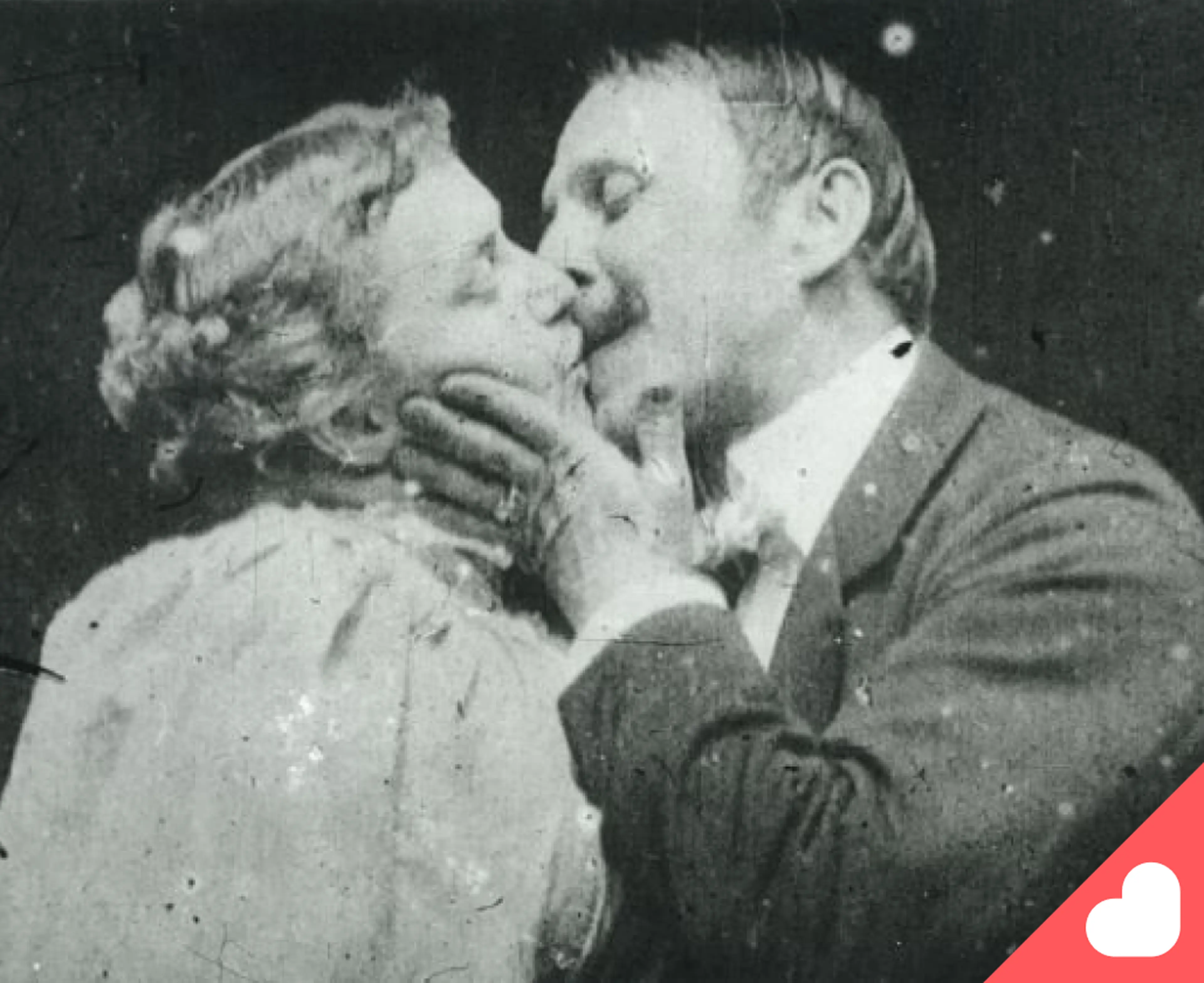 Vintage black and white cinema trivia still showing a man and woman kissing in an early silent film scene, with a red heart icon in the corner