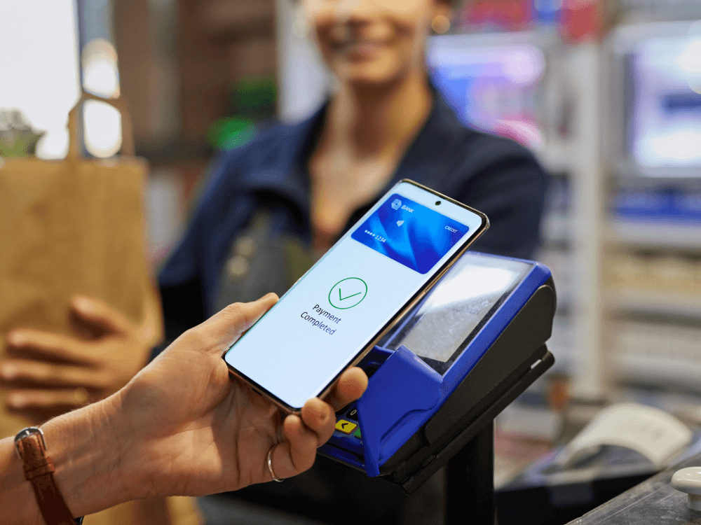 Paypoint Card Machine A person uses a smartphone to make a contactless payment at a store ...