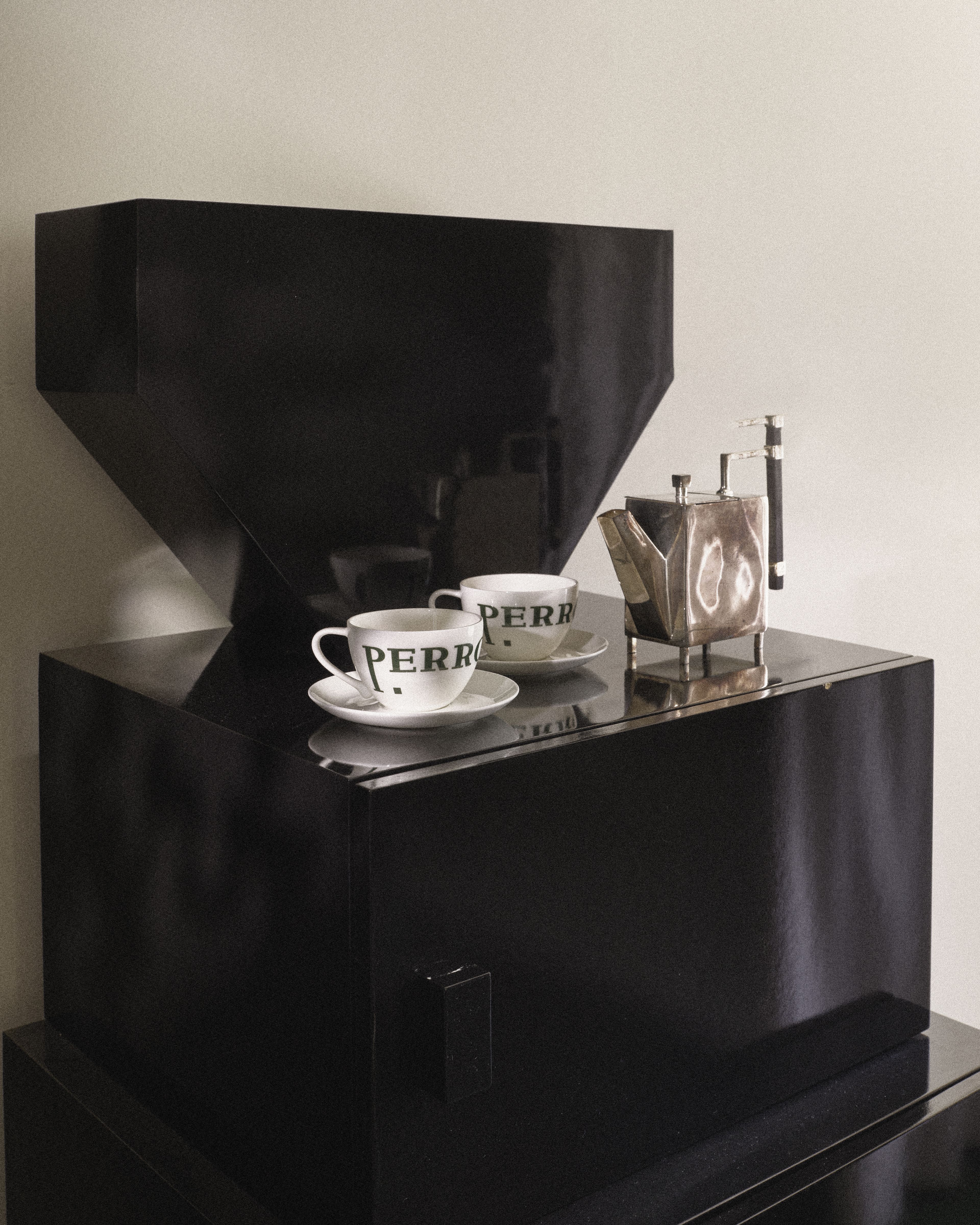 Close-up of Perroquet Hotel coffee station with branded cups and premium espresso maker.