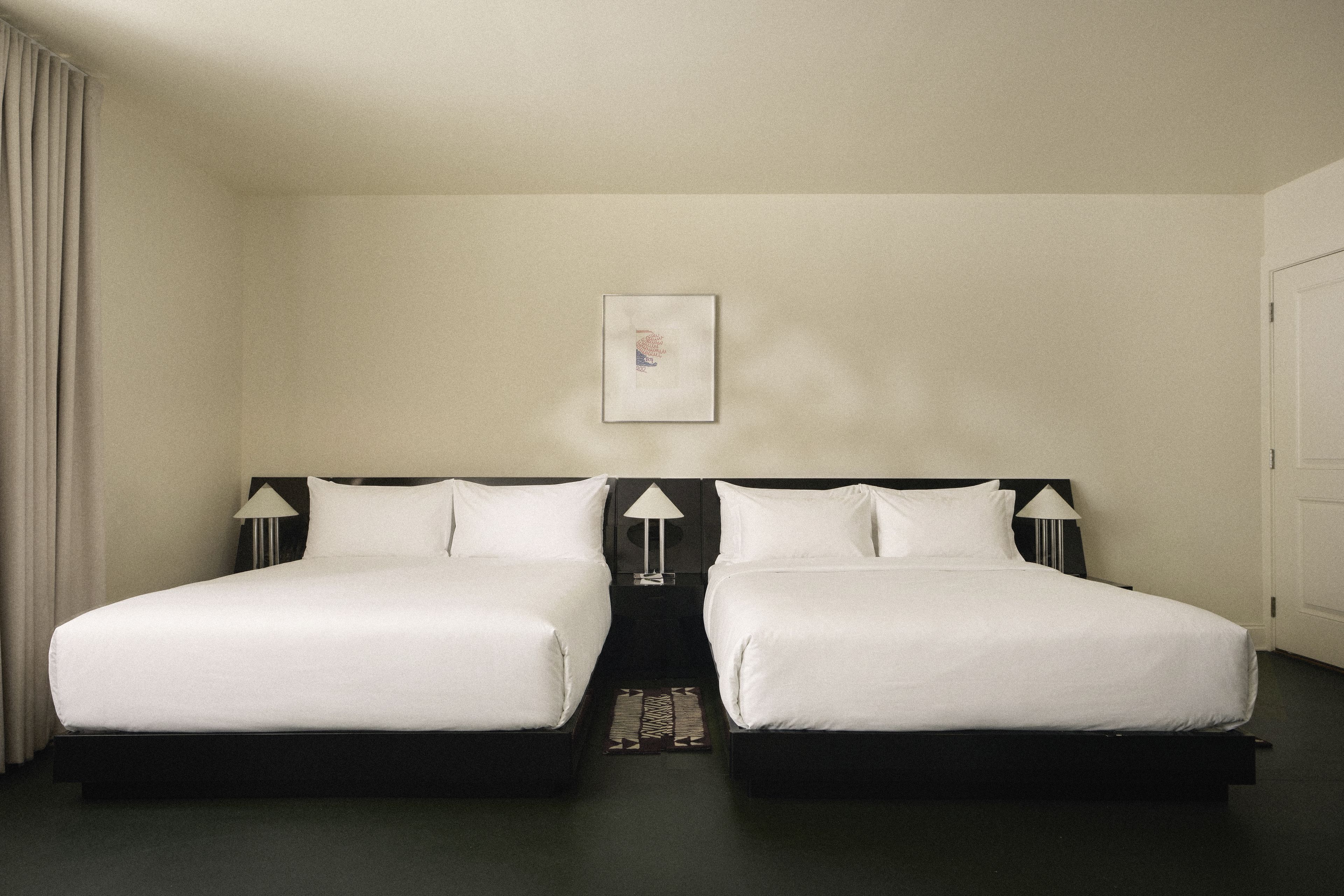 Spacious guest room with two queen beds and contemporary furnishings at Perroquet Hotel in Fort Lauderdale.