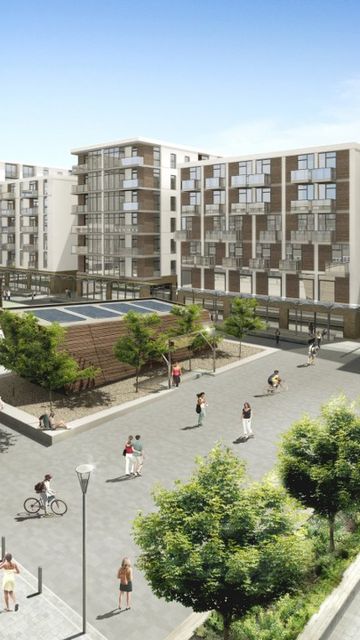 Modern urban development with multi-story buildings, balconies, greenery, and people walking and cycling in a spacious courtyard under a clear blue sky.