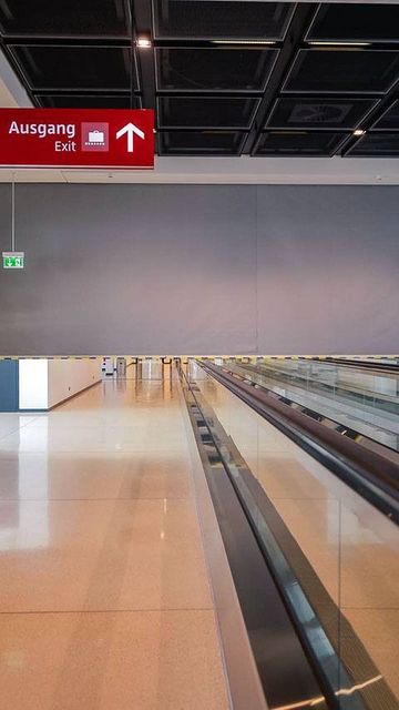 Empty airport terminal with a smoke curtain. Features include a moving walkway, red signs indicating exits and gates A01-36, a large "7" on the wall, and a trash bin in the corner.