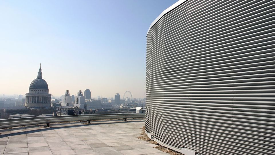 Rooftop view of the London skyline with St Paul's Cathedral and the London Eye. On the roof is a screening louvre.
