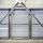 Metallic structure with diagonal beams and horizontal louvered panels, allowing light through, creating an industrial appearance.