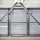 Metallic structure with diagonal beams and horizontal louvered panels, allowing light through, creating an industrial appearance.