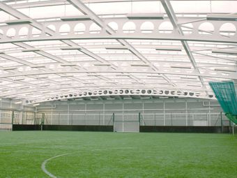 An indoor football academy field with artificial turf.