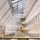 Modern, spacious atrium with a glass ceiling, large windows, and several floors visible. Ample natural light creates an open, airy atmosphere.