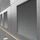 Metal-clad industrial building with large vented panels and parallel-lined corrugated texture, adjacent to a paved pathway.