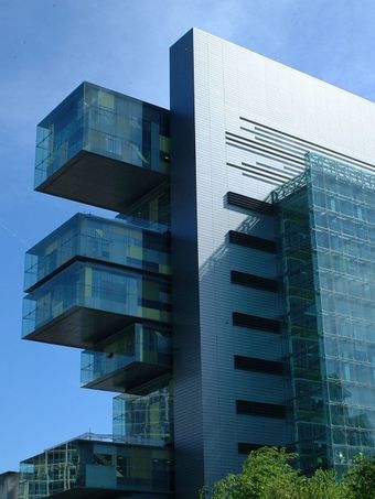 Civil Justice Centre in Manchester, a modern building with protruding glass cube structures and a sleek design, set against a clear blue sky.