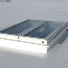 A flat white rooftop with a rectangular Firelight Duo featuring two glass panels framed in white.