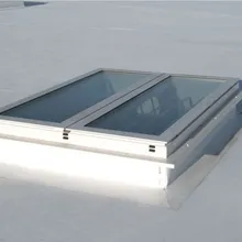 A flat white rooftop with a rectangular Firelight Duo featuring two glass panels framed in white.