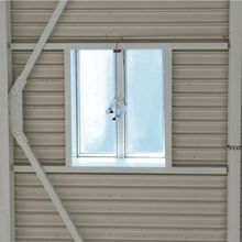 A Firelight Duo with frosted glass framed by structural beams on a ribbed metal wall.