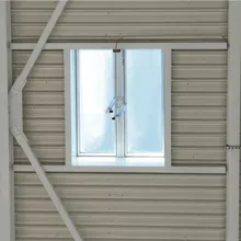 A Firelight Duo with frosted glass framed by structural beams on a ribbed metal wall.