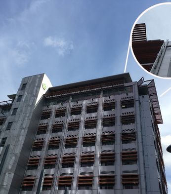 Tall building with metal facade and protruding sunshades under a blue sky. Inset shows a close-up of the brise soleil.