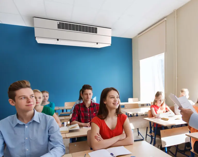 Klassenraum mit Schülern und DEX3000 Lüftungsgerät an der Decke