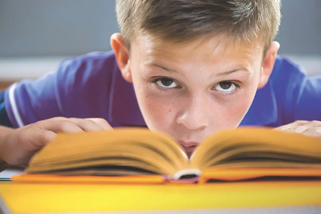 Schulkind mit aufgeschlagenem Buch