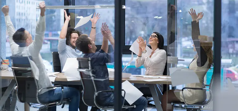 Happy workers in meeting clapping