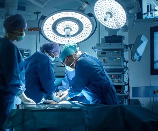 Equipe médica realizando uma cirurgia em um centro cirúrgico iluminado.