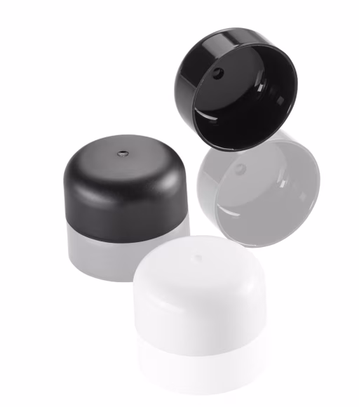 Three bottle caps are shown: one black with a reflective interior, one solid black, and one white, all with button tops.