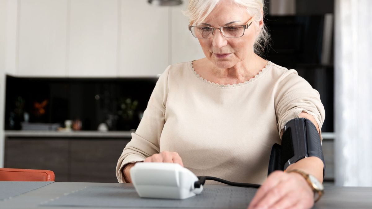 Woman 60 and up reading her blood pressure
