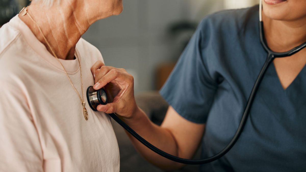 Healthcare provider listening to a woman's heart during a routine exam.