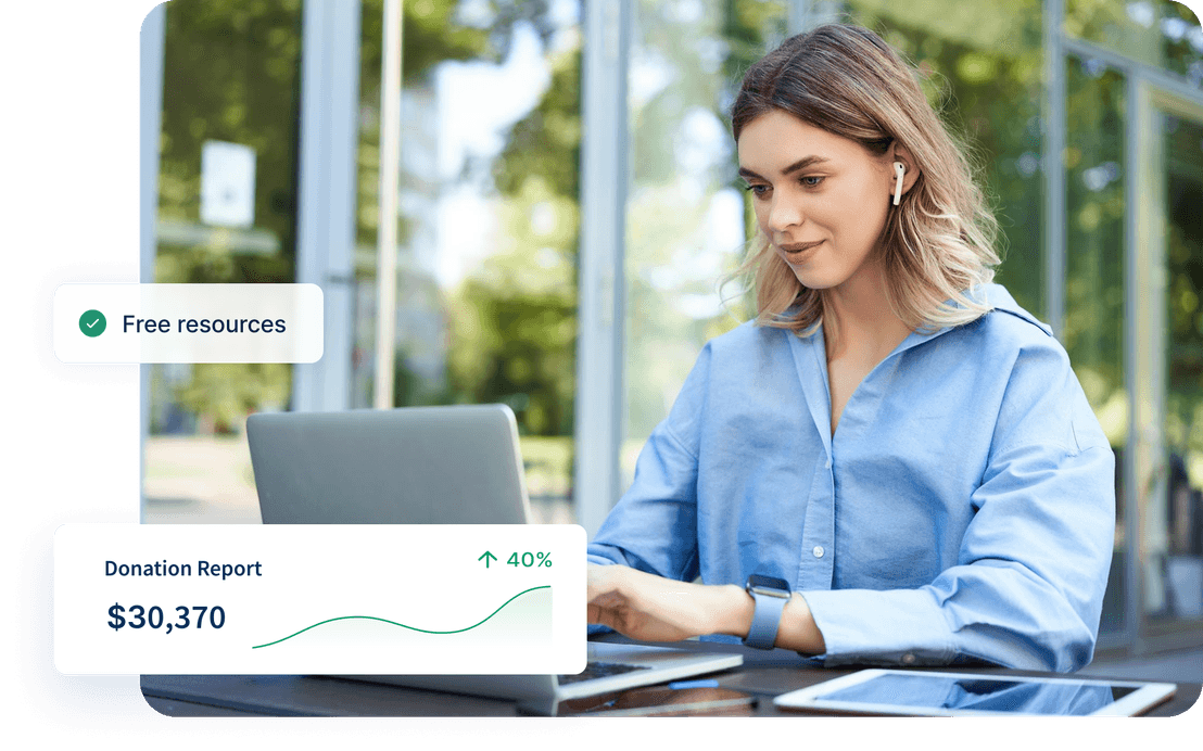 Woman in blue shirt using laptop outdoors with graphs showing donation growth and "Free resources" pop-up.