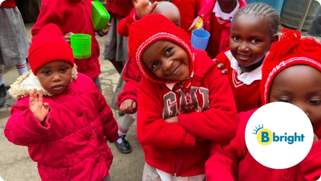 Children in red uniforms and beanies smile and wave at the camera. A "Bbright" logo appears on the bottom right.