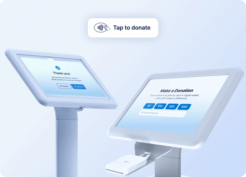 Two white donation kiosks with touchscreens display donation options and a "Tap to donate" sign above.