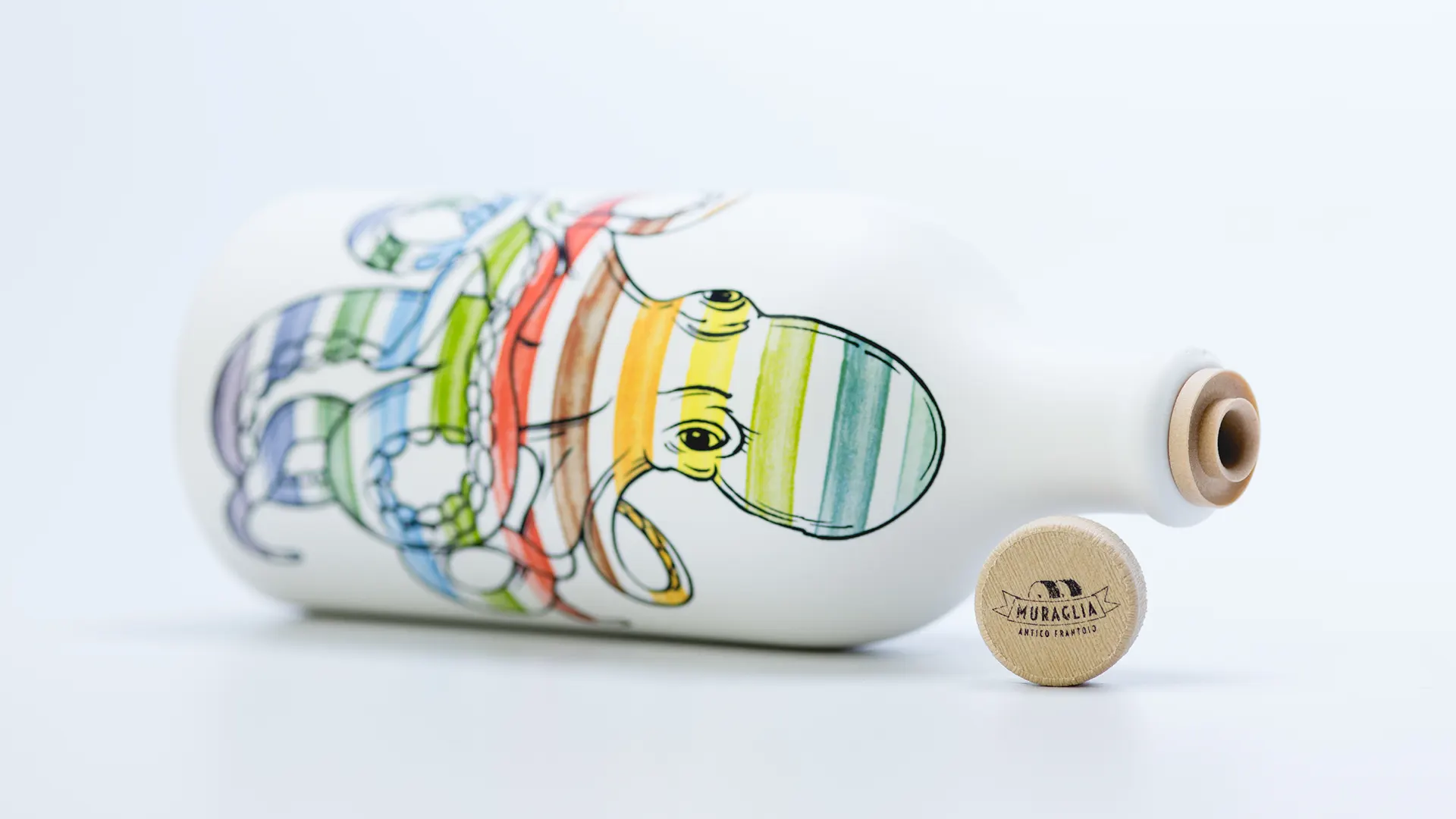 Olio Muraglia Orci di Mare in posizione orizzontale: primo piano dell'orcio con illustrazione di un polpo a strisce multicolore e tappo in legno naturale