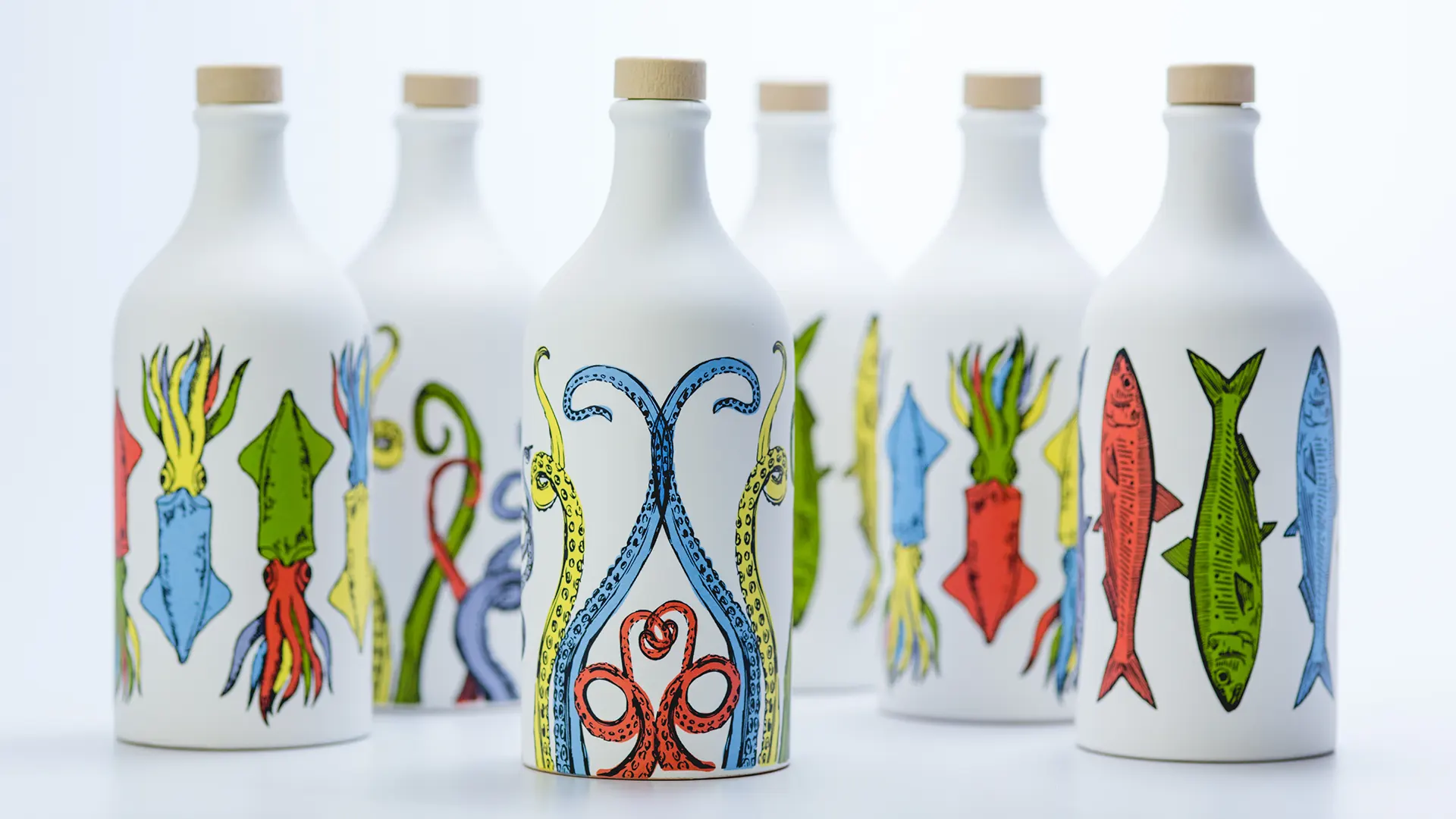 Vista frontale della gamma completa degli orci in ceramica Muraglia Orci di Mare, decorati con illustrazioni di creature marine a colori vivaci su fondo bianco