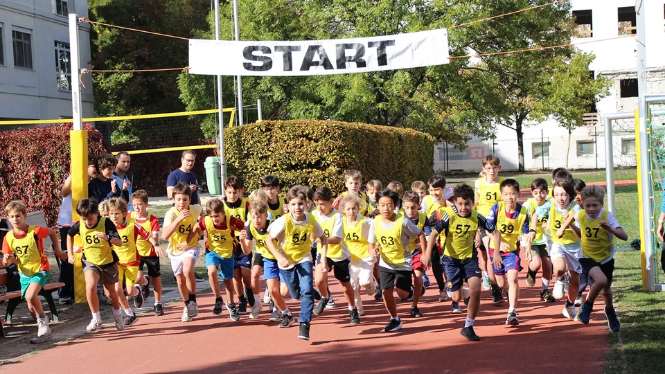 Gruppe von jungen Burschen beim Start auf einer Laufbahn im Freien