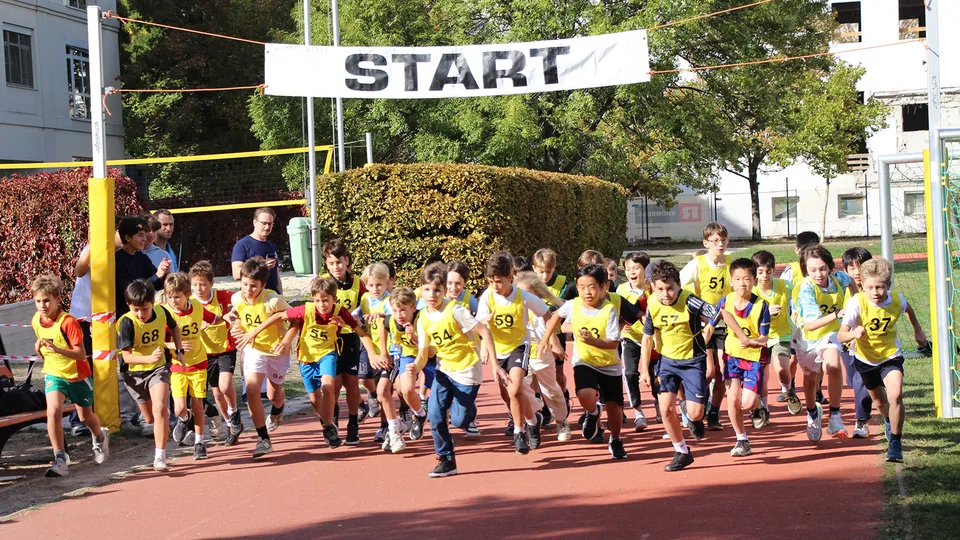 Gruppe von jungen Burschen beim Start auf einer Laufbahn im Freien