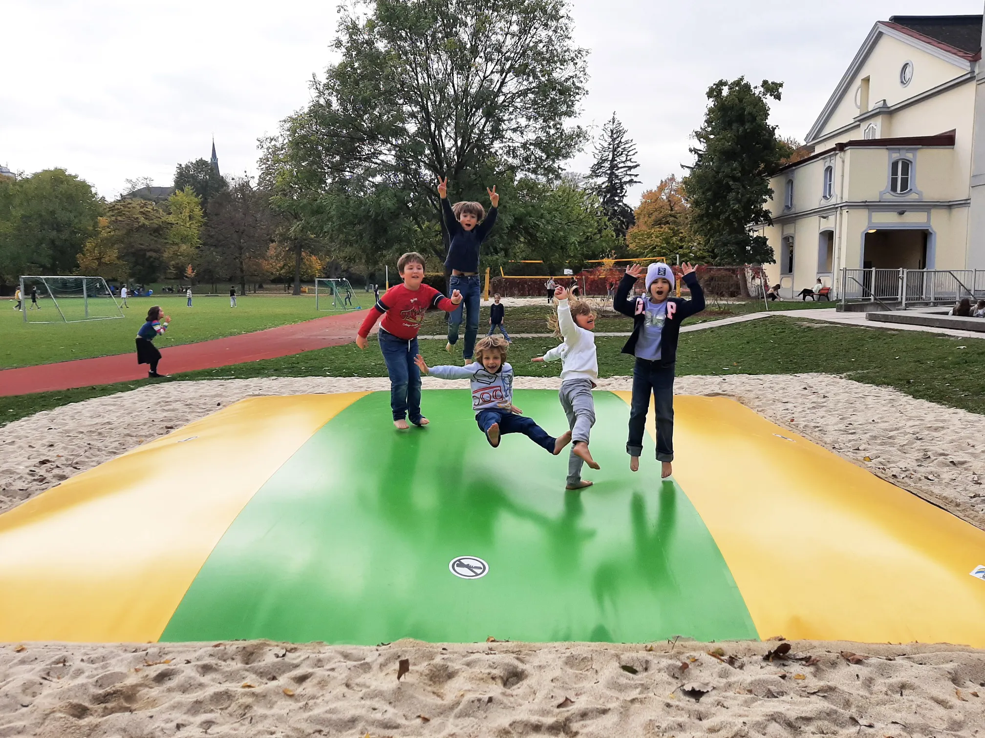 Fünf Burschen auf einer Hüpfblase ausgelassen springend