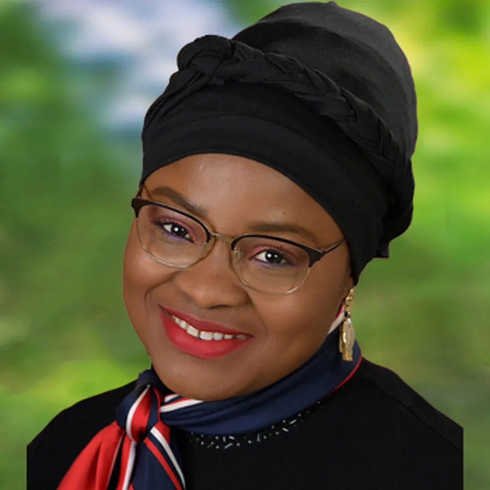 Portrait einer Frau mit Brille und Turban und einem rot blauen seidigem Halstuch