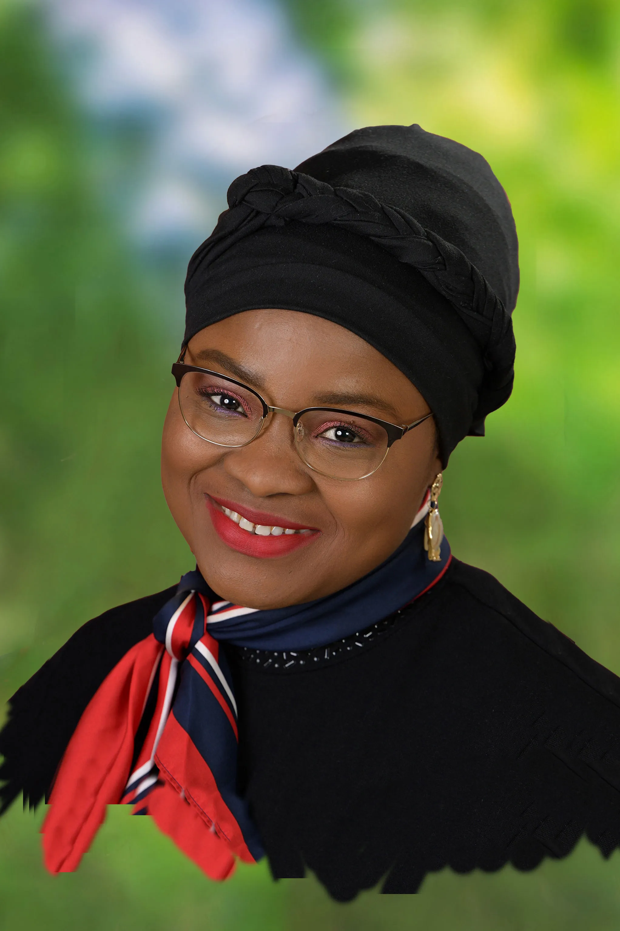 Portrait einer Frau mit Brille und Turban und einem rot blauen seidigem Halstuch