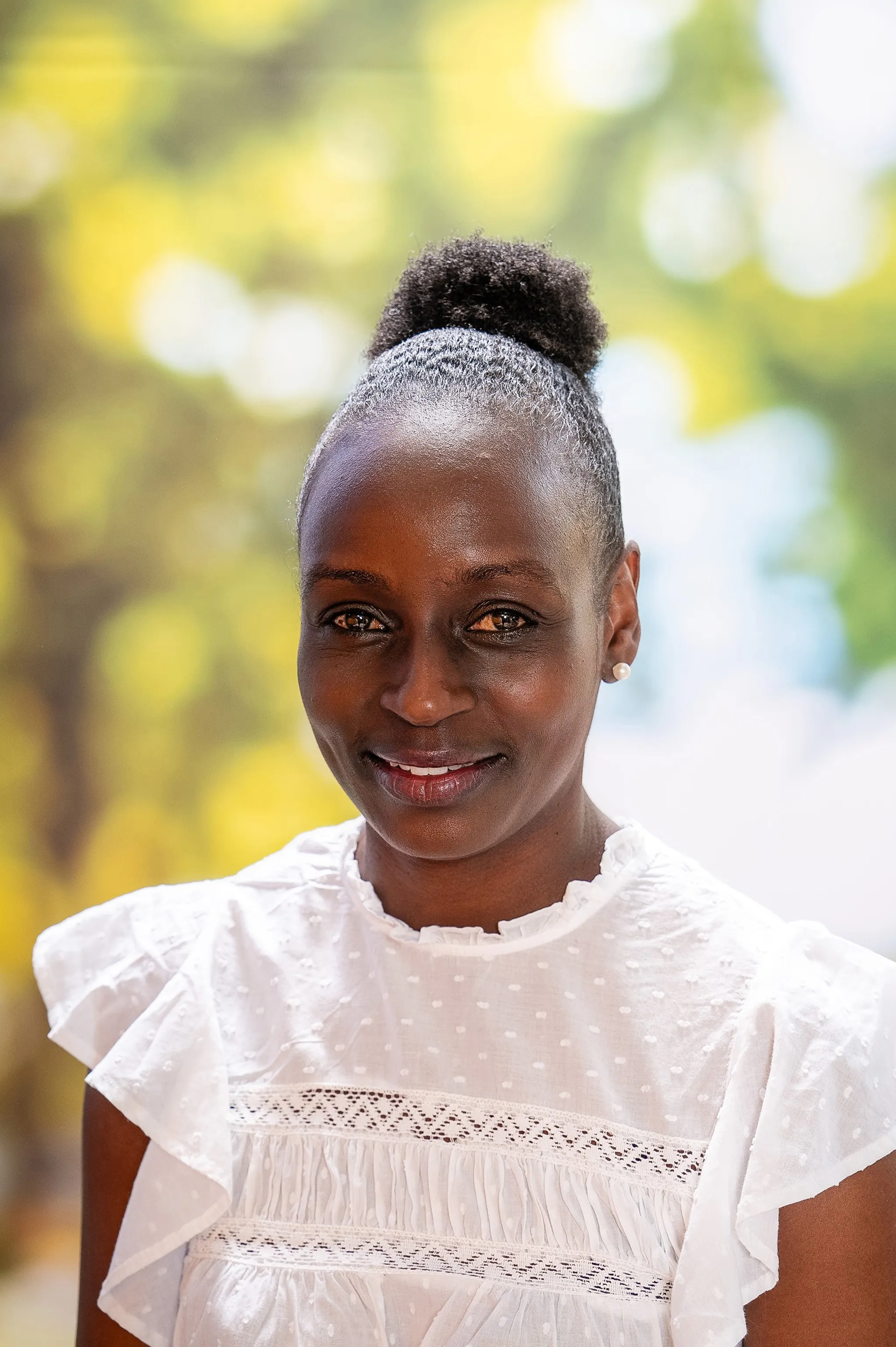 Lachende Frau in einer weißen Bluse mit hochgebundenem Haar