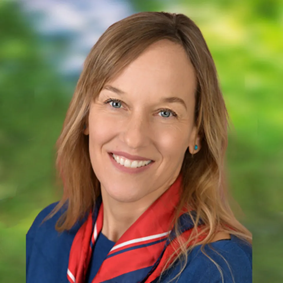 Portrait einer Frau freundlich lachend mit blonden Haaren und rotem Halstuch