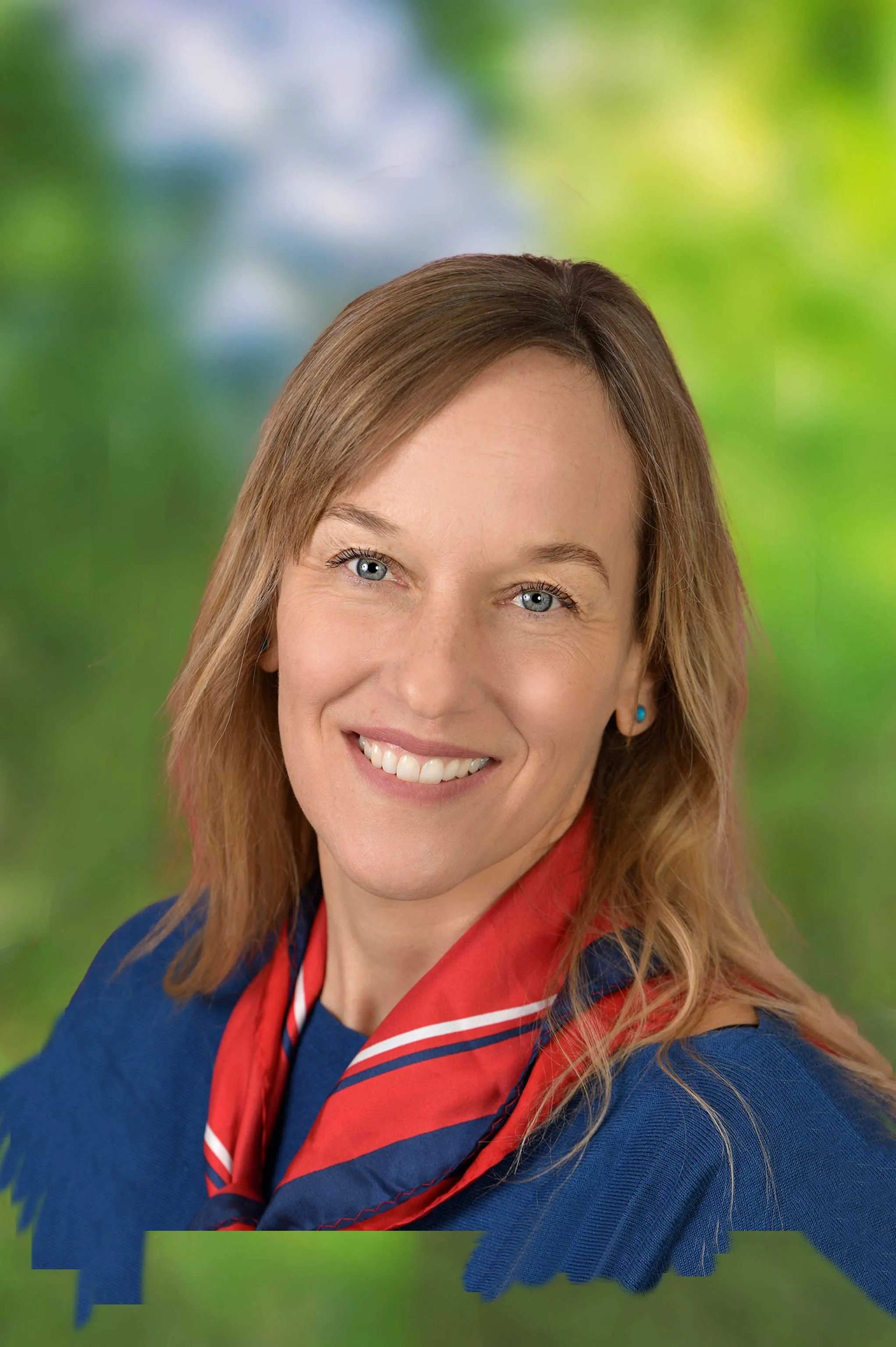 Portrait einer Frau freundlich lachend mit blonden Haaren und rotem Halstuch