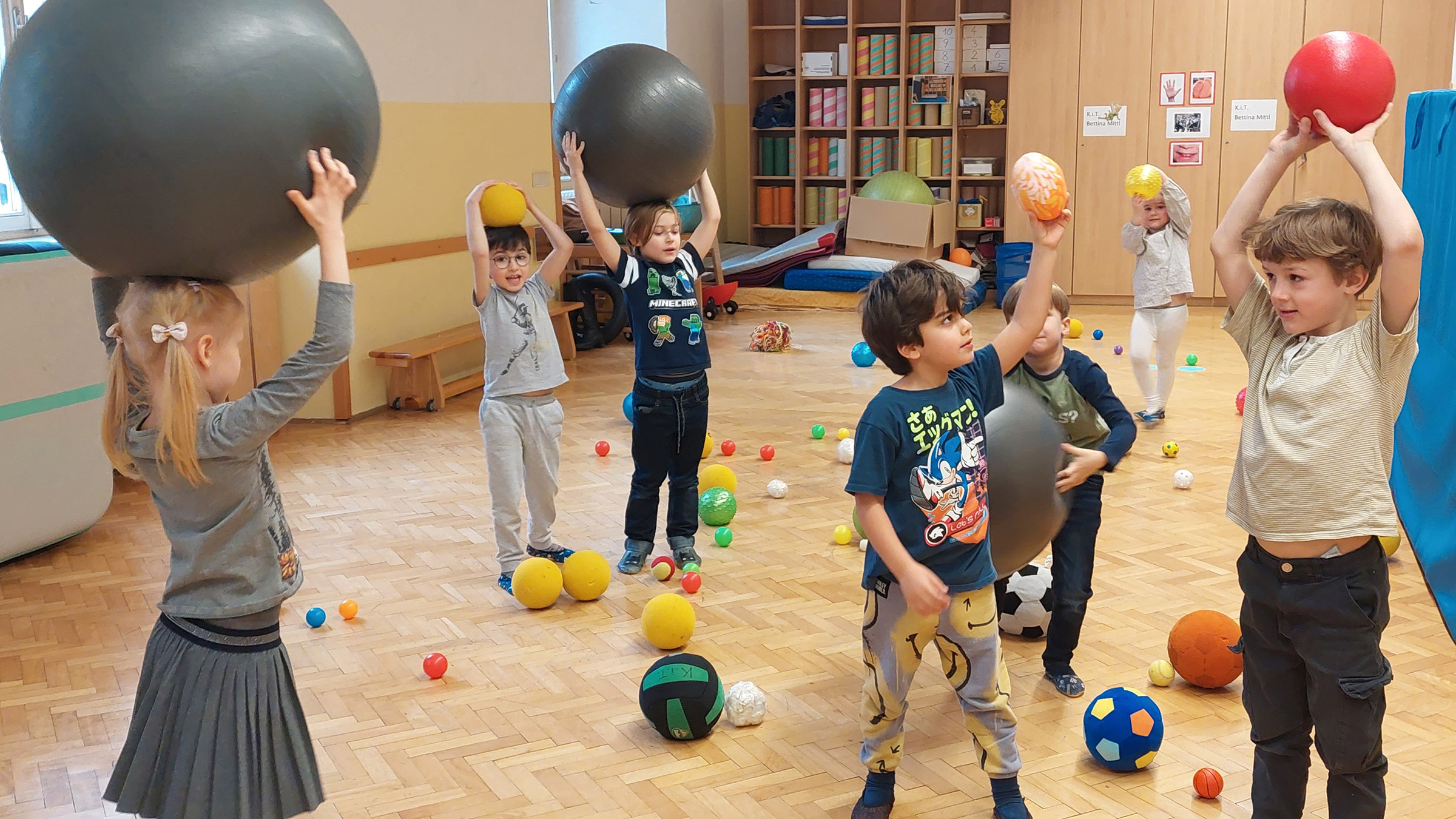 Gruppe von Vorschulkindern mit vielen Bällen in unterschiedlichen Größen und Farben